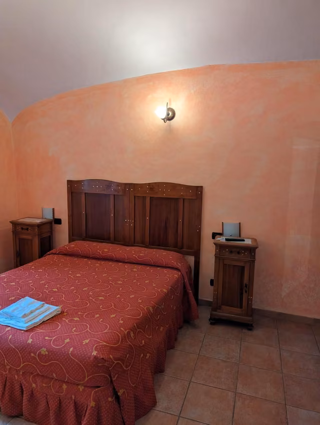 Camera con letto e arredi in legno del Rifugio del Lupo