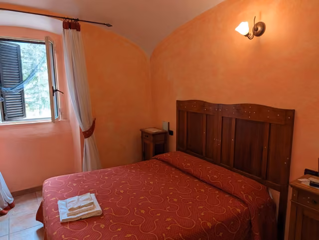 Camera con letto matrimoniale e finestra del Rifugio del Lupo
