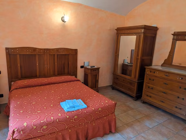 Camera del Rifugio del Lupo con letto, cassettiera e specchio